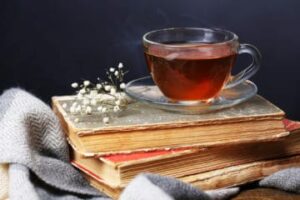 a cup of hot tea on top of some books