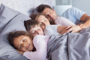 family of four sleeping together
