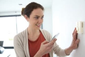 woman-checking-the-wireless-thermostat