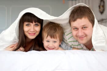 a family smiling on the bed
