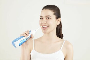 young woman using water flosser