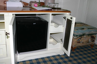 A small refrigerator inside a kitchen cabinet