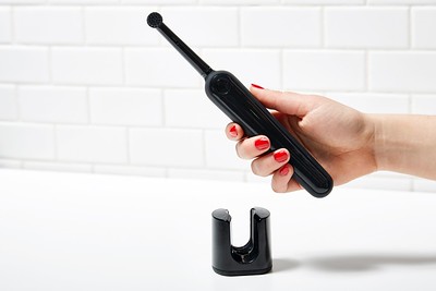 a-woman’s-hand-holding-a-black-oral-hygiene-tool