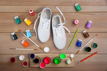 White shoes and painting equipment on wooden table