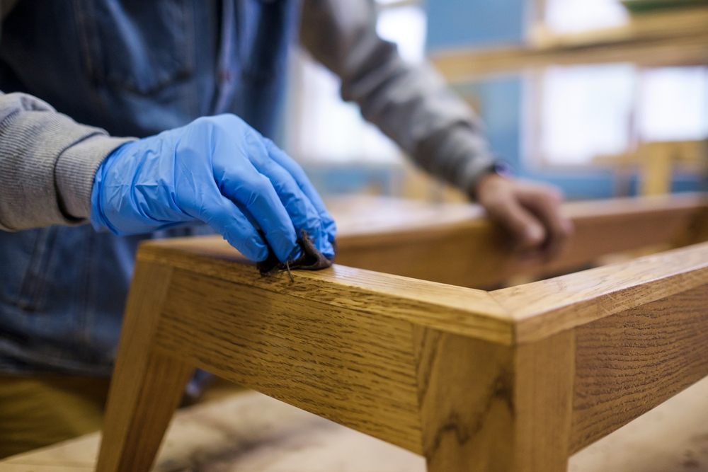 Woodwork protective oil being applied on wooden furniture