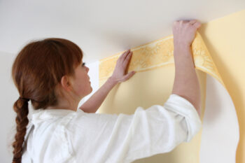 a woman decorating her wall border